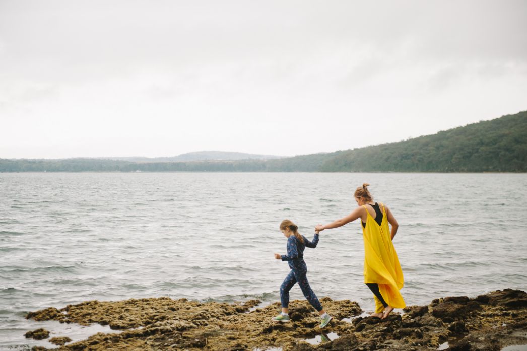 Chloe and Ann Marie walking on rocks at the water's edge